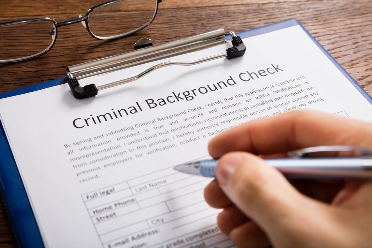 Close Up,of,person,hand,filling,criminal,background,check,application,form